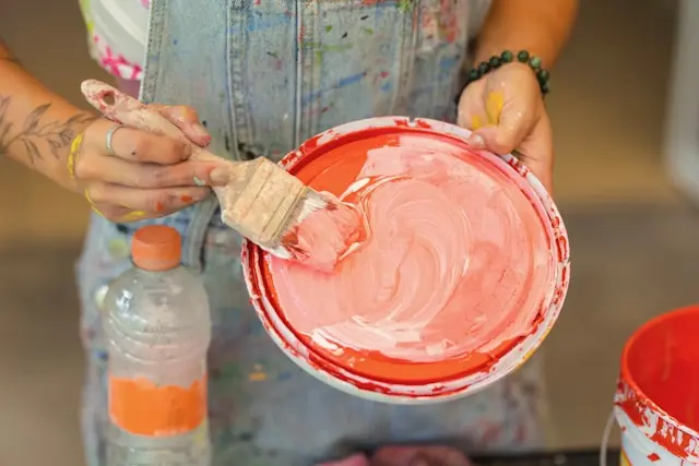 tapa con pintura mezclada y un hombre con una brocha